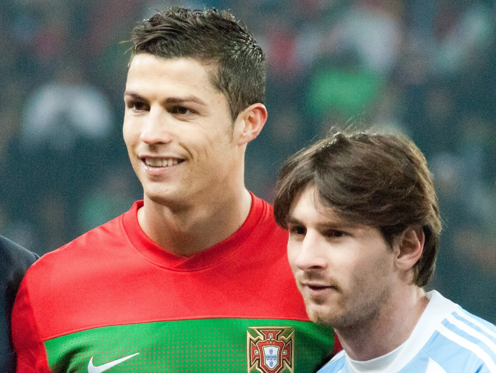 Cristiano Ronaldo in Portugal's red shirt and Lionel Messi in Argentina's white and sky-blue shirt stand side by side on the pitch before a match
